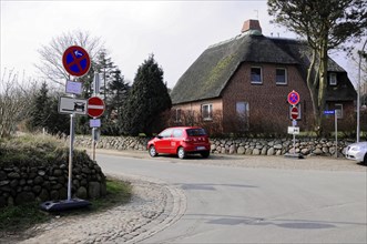 Sylt, North Frisian Island, Schleswig Holstein, Street corner with traffic sign next to a thatched