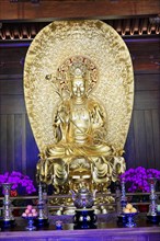 Jade Buddha Temple, Shanghai, Golden Buddha statue on an altar surrounded by pretty flowers,