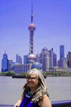 Stroll through Shanghai to the sights, Shanghai, China, Asia, A woman smiles with the skyline of