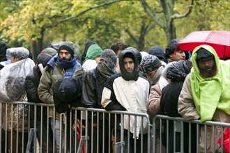 Syrian refugees wait for their registration in cold and wet weather at the Berlin State Office for