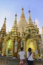 Shwedagon Pagoda, Yangon, Myanmar, Asia, Visitors marvel at the glowing golden spires of the
