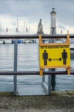 Advertising sign for physical distancing on the harbour railing in the old town of Lindau (Lake
