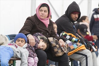 A Syrian refugee family and their children wait in a tent at the Berlin State Office for Health and