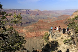 Visitors marvelling at the view of the Grand Canyon under a clear blue sky, Grand Canyon National