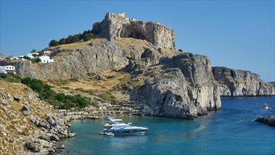 Medieval castle above a town on the coast with boats in the water, Paulus Bay, below the Acropolis
