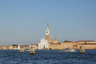 Canal lane markers in Venetian lagoon and 16th century Benedictine church of San Giorgio Maggiore