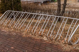 Empty stainless steel public bicycle rack next to red brick sidewalk in South Korea