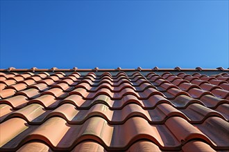 Close up of roof with red ceramic tiles and blue sky. KI generiert, generiert, AI generated
