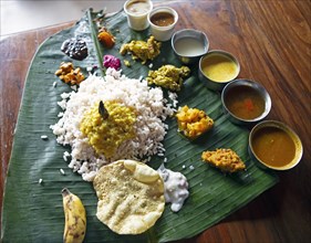 Sadya or variety of traditional vegetarian dishes served for lunch on a banana leaf, Kerala, India,