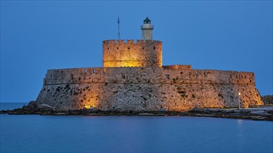 Ancient castle walls with a lighthouse in the blue hour in a quiet atmosphere, night shot, Fort of