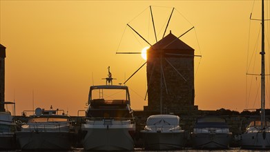Windmill and boats silhouetted against a sunrise backdrop, twilight, Mandraki Oat, Rhodes,