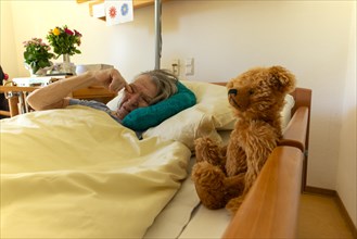 Senior citizen with dementia lying in her room in a retirement home, portrait, Baden-Wuerttemberg,