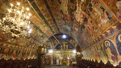 Interior view of an Orthodox church with richly decorated frescoes and an iconostasis, Panagia