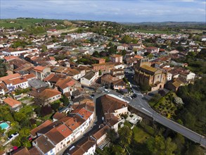 Aerial view of a town with narrow streets between densely built-up blocks of flats, Venerque,