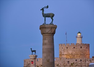 Deer statue on a pillar in front of a fortress wall and a lighthouse at dusk, Deer statue, Deer