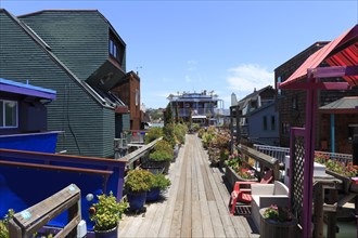 A path between colourful floating houses and flowers under a bright sky, San Francisco, North