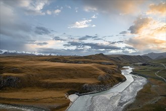Mountain valley with Sary Jaz river at sunset, high glaciated mountain peaks of the Tien Shan in