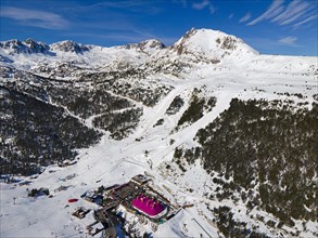 Aerial view of a mountain station with surrounding ski slopes in a winter landscape, Grau Roig,