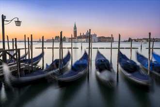Venetian gondolas, boat dock at St Mark's Square, church of San Giorgio Maggiore in the background,