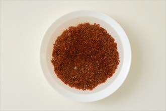 Top view of soaked pink rice grain in a bowl