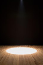 Single focus of light on a theater stage without anything, focus of light on a wooden floor and