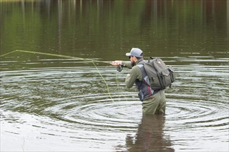 Black bass fisherman fishing inside lake, Cambara do sul, Rio Grande do sul, Brazil, South America