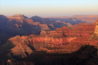 The crimson light of sunset paints the rock formations of the Grand Canyon, Grand Canyon National