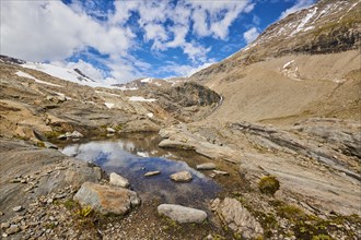 Puddle next to Wasserfallwinkelkeesee in the mountains (Grossglockner) in summer on a sunny day,