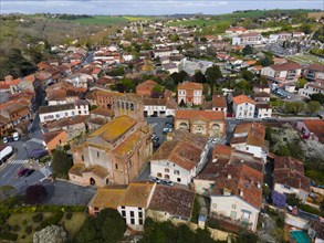 Aerial view of a small town with historic architecture and streets surrounded by landscape, parish