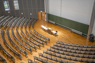 View from above into an empty lecture theatre with rows of seats and lectern, interior photo,