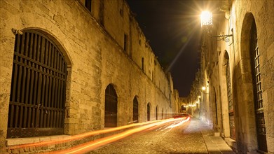 Long exposure of an old street at night with light traces of a vehicle on the side, Ritterstrasse,