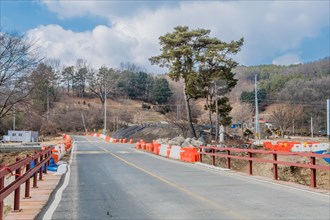 Traffic barriers on each side of two lane rural road construction site in South Korea