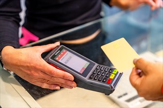 Close-up of the hands of a client paying with credit card using contact less technology in a hair