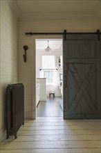 Kid's upstairs floor bathroom with distressed barn wood door, black honeycomb ceramic tile floor,