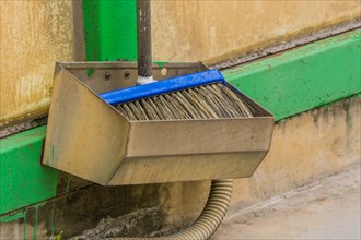 Car wash brush in metal holding trough mounted on green support beam in South Korea