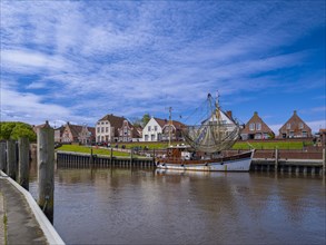 Fishing boat and historic houses at Greetsiel harbour, Greetsiel, Krummhoern, East Frisia, Lower
