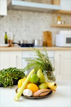 Fresh vegetables, herbs and fruits on a kitchen table