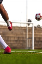 Football player feet running with the ball in front of the field. Player feet with the ball scoring