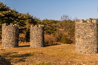 Three stone structures resembling castle towers at public mountain park on sunny day in Yesan,