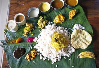 Sadya or variety of traditional vegetarian dishes served for lunch on a banana leaf, Kerala, India,