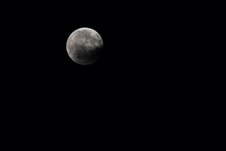 Full moon at night, partially covered by a cloud, Bavaria, Germany, Europe