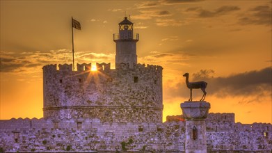 Lighthouse on a castle, pierced by the rays of the rising sun, sunrise, dawn, European roe deer