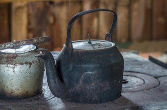 Beautiful steel kettle on wood stove in the countryside