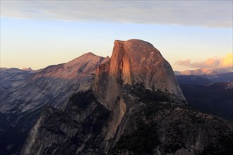 The sun illuminates a massive rock in a mountainous area during sunset, San Francisco, North