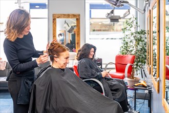 Hairstylist working in a beauty salon combing the hair of a customer