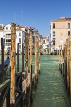 Mooring poles and gondola on Grand Canal with Renaissance architectural style residential palace