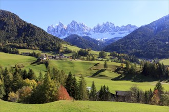 Autumn mountain landscape with a village surrounded by colourful trees, Italy, Trentino-Alto Adige,