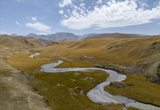 Aerial view, Kol Suu River winds through a mountain valley with hills of yellow grass, Naryn