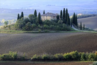 Secluded farmstead on a hill in Tuscany surrounded by cultivated fields, Italy, Tuscany, Podere