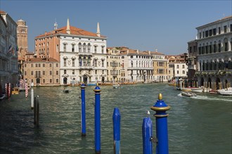 Blue mooring posts and water taxis on Grand canal with Renaissance architectural style residential